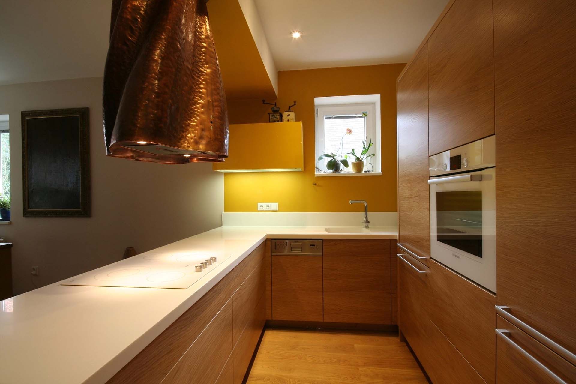 Moderní kuchyně na míru s teplými odstíny a výraznou měděnou digestoří